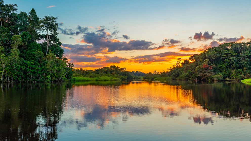 Spiegelung eines Sonnenuntergangs über einer Lagune im Amazonas-Regenwaldbecken.